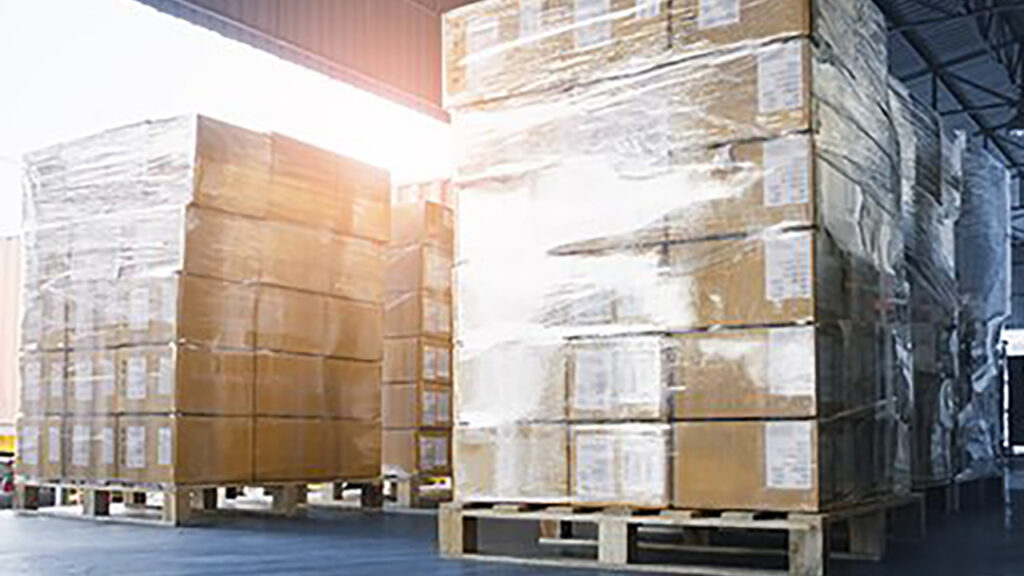 shrink-wrapped cartons on pallets on loading dock
