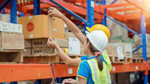 two workers inspecting a shipping carton in a warehouse